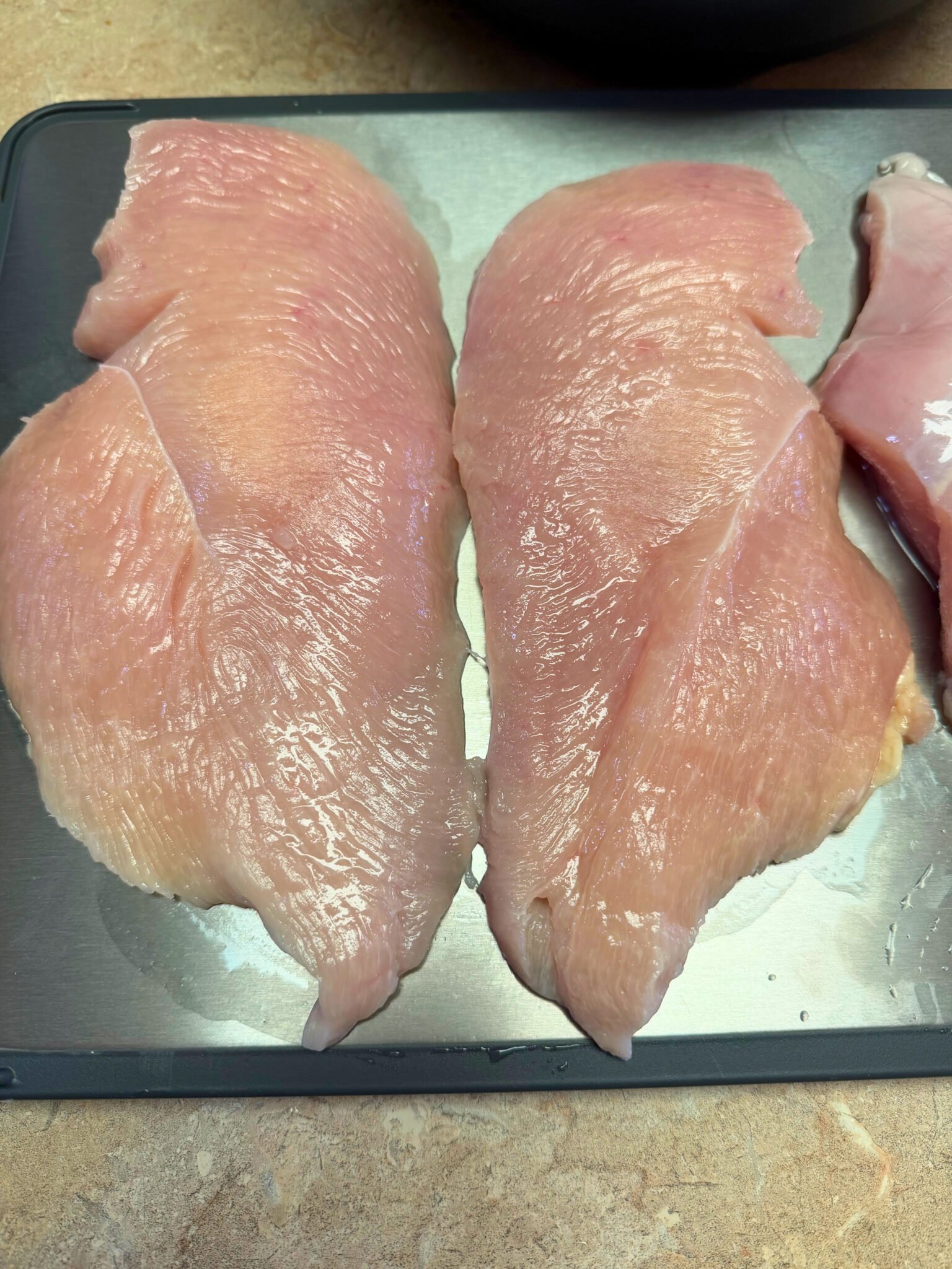 Butterflied chicken breasts topped with cottage cheese layer for low carb chicken parm