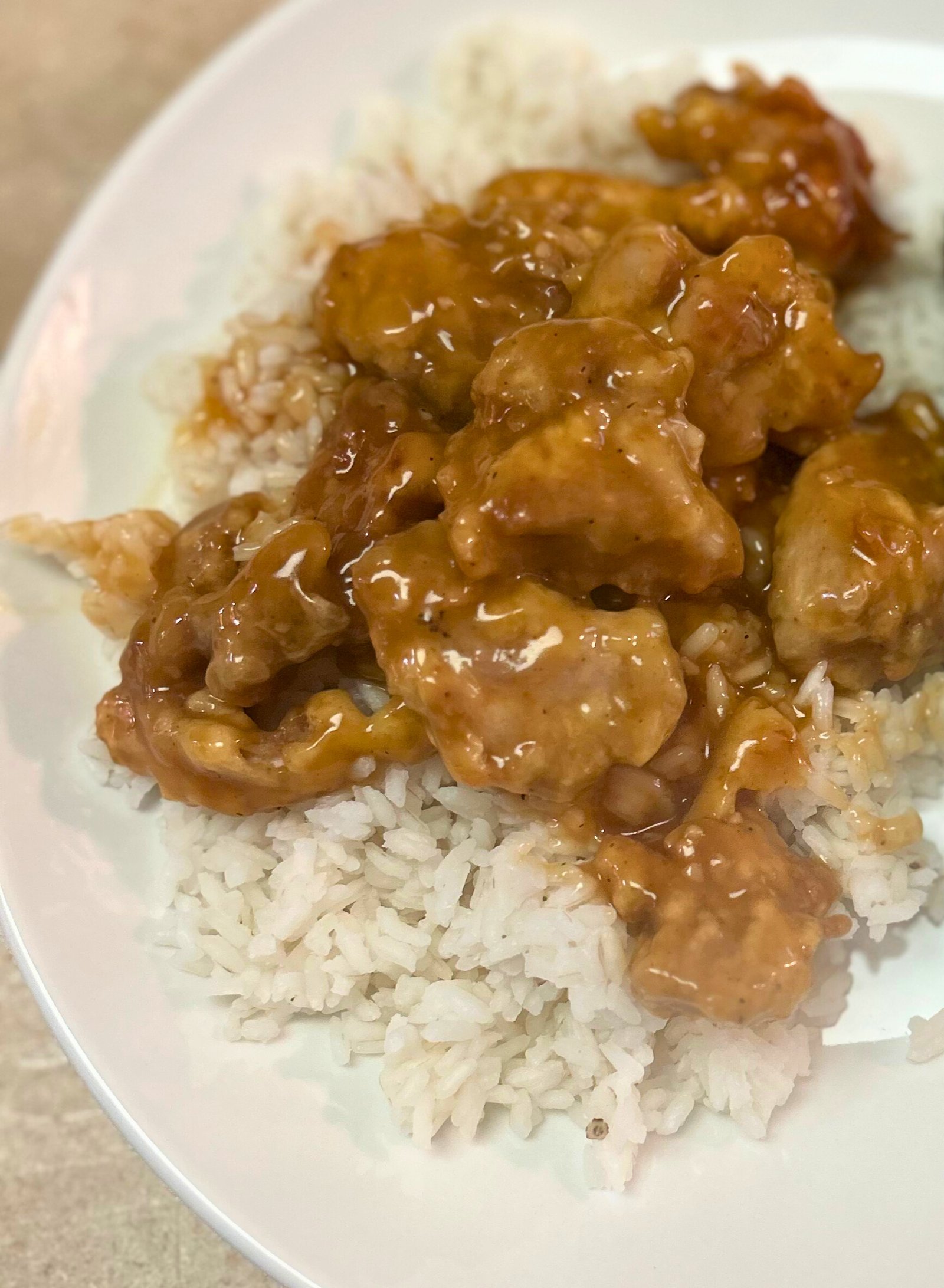 Easy 30-minute healthy orange chicken close-up with sticky glossy orange glaze