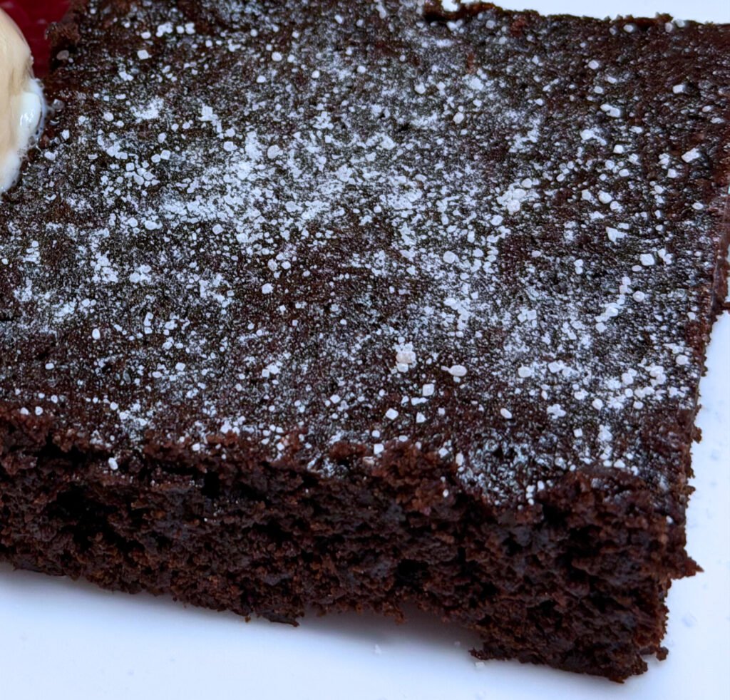 Simple pantry staple ingredients for homemade brownies — cocoa powder, sugar, flour, butter, and eggs