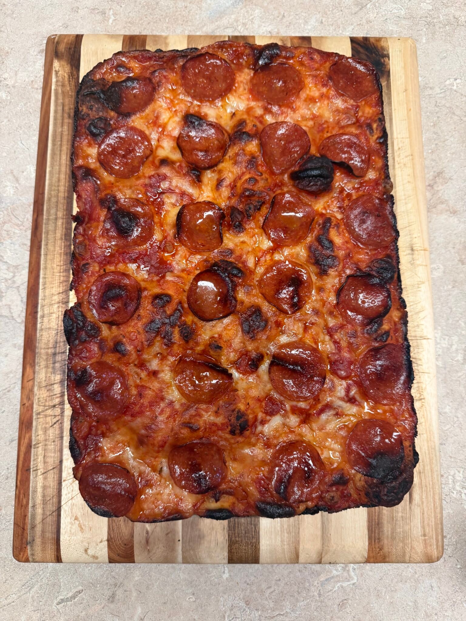 Easy sourdough Detroit-style pizza with crispy frico cheese crust and classic red-top sauce stripes