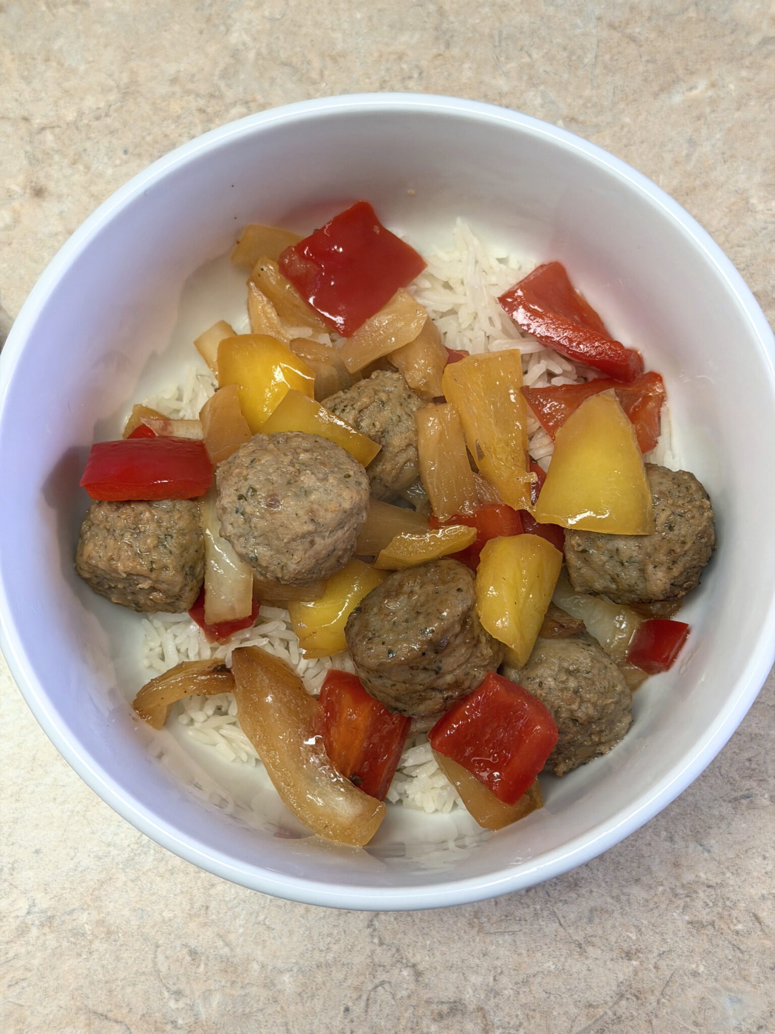 Easy slow cooker teriyaki meatballs with colorful bell peppers and sesame seeds served over rice
