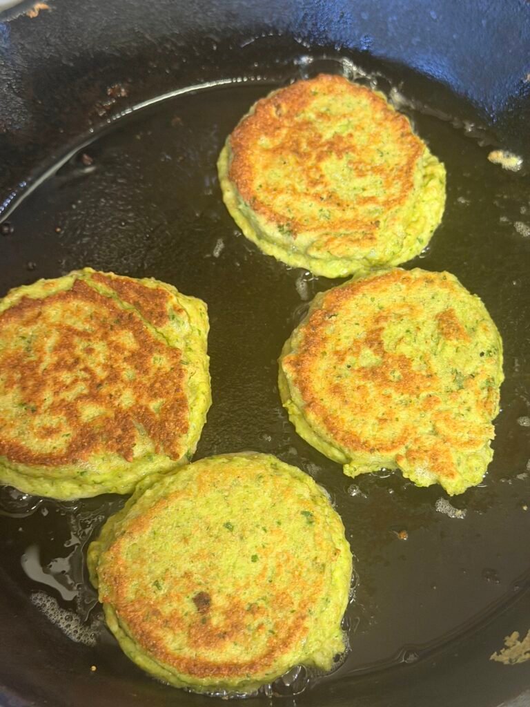 Golden edamame fritters served on a plate with yogurt dipping sauce