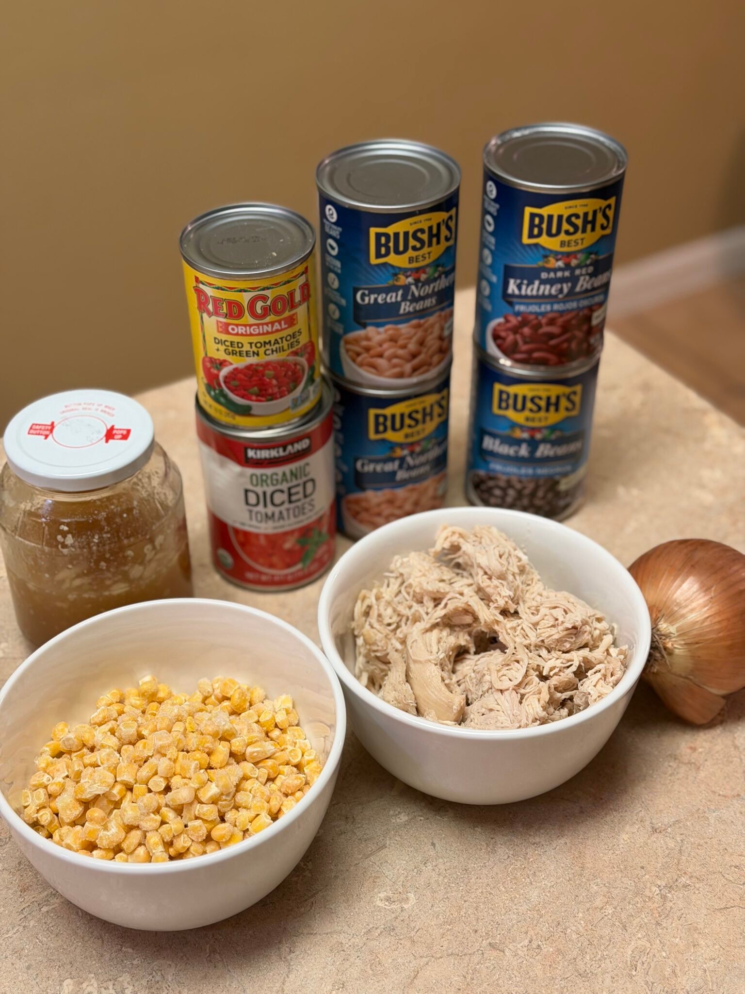 Chicken tortilla soup ingredients including beans, shredded chicken, and spices