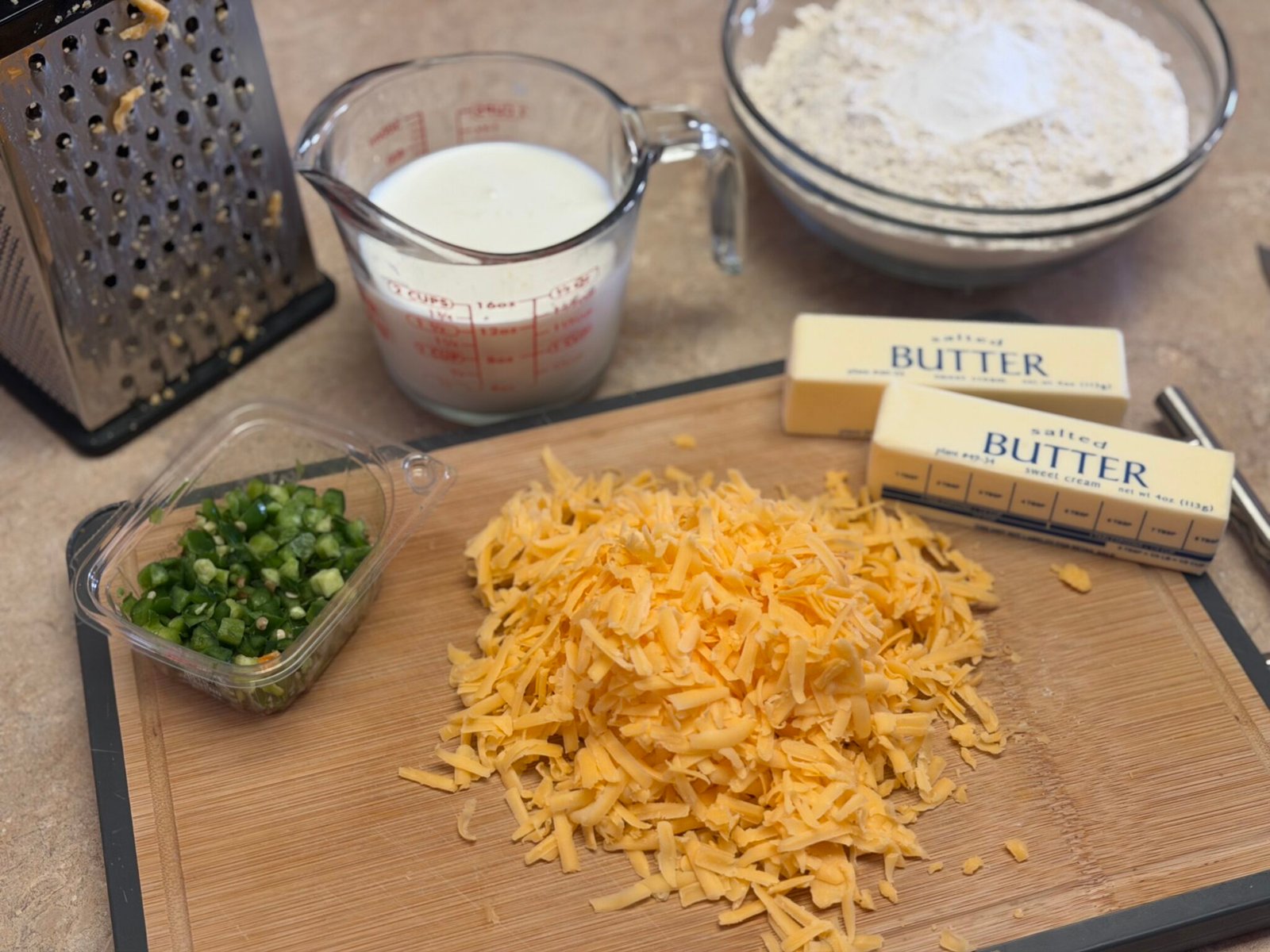 Cheddar jalapeño scone dough being worked with cold butter and flour